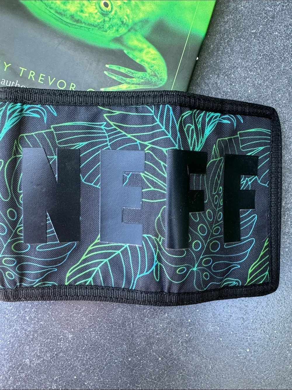 NWOT NEFF black background with tropical theme trifold wallet. Zipper pocket.